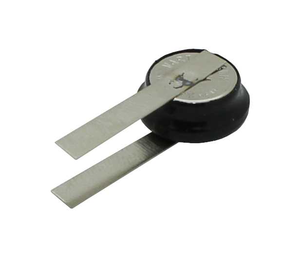 Runde Knopfzelle mit zwei flachen Metalllaschen in U-Form auf weißem Hintergrund