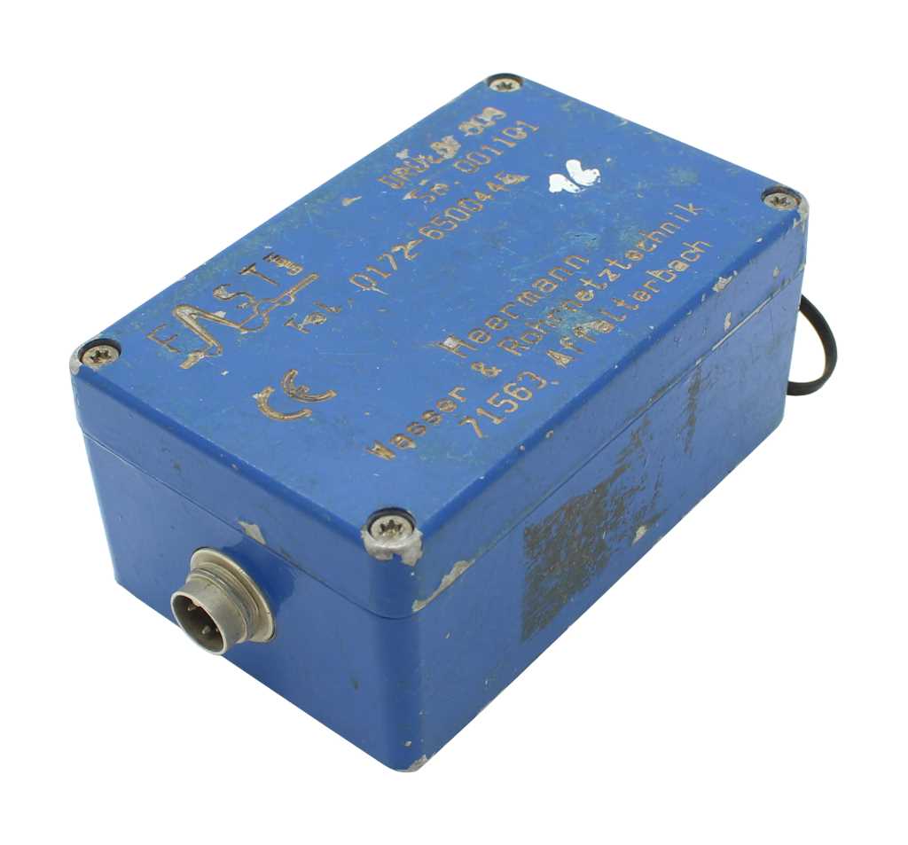 Blaue rechteckige Metallbox mit vier Schrauben, seitlichem Rundstecker und sichtbaren Kratzern und Abnutzung