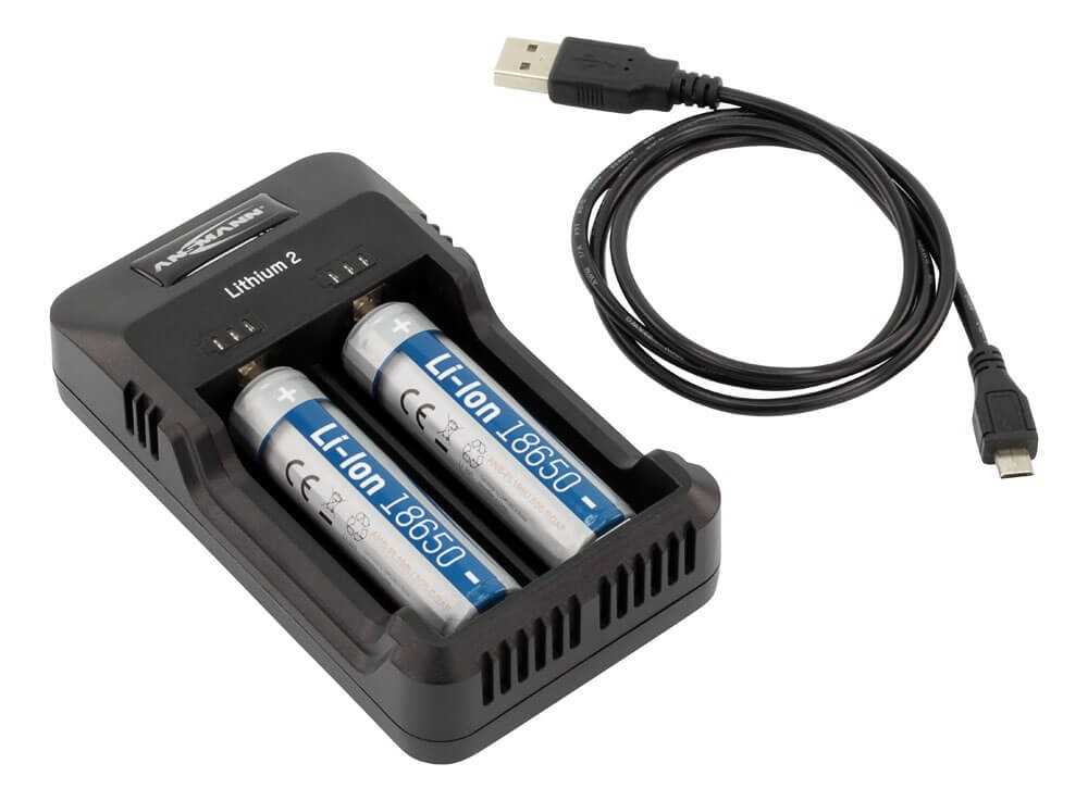 Schwarzes Akkuladegerät mit zwei eingesetzten 18650-Zellen und danebenliegendem USB-Kabel